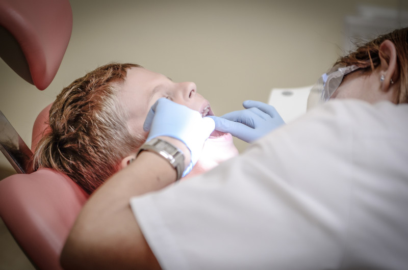 A dentist works on a child’s teeth.